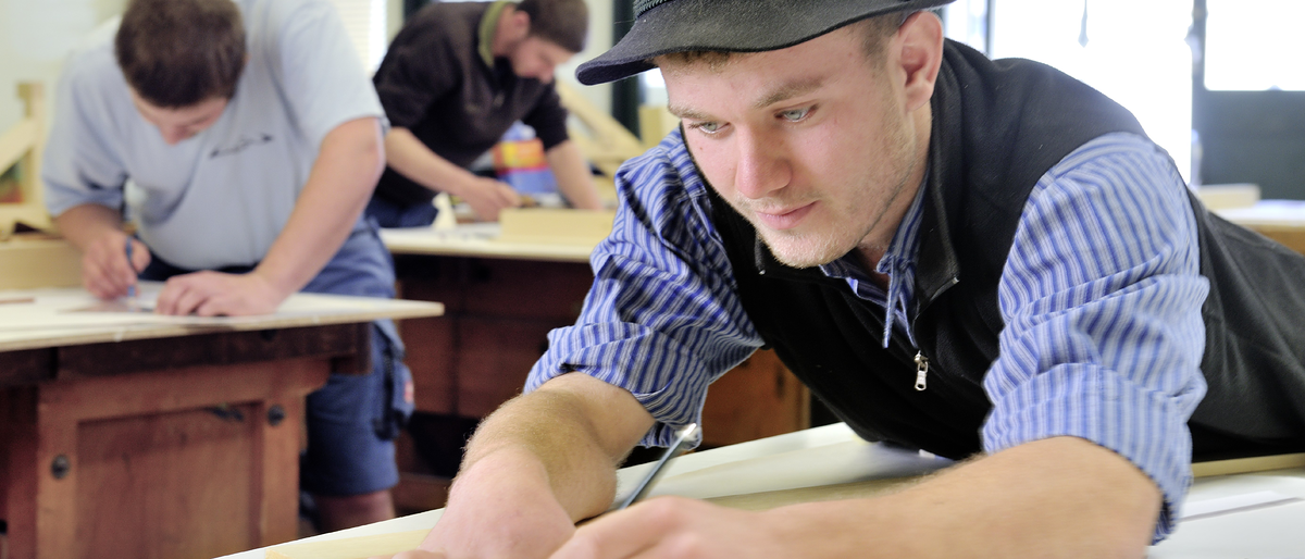 Zimmerer, Aufzeichnen eines Planes, Hut, Werkstatt, konzentrierte Arbeit