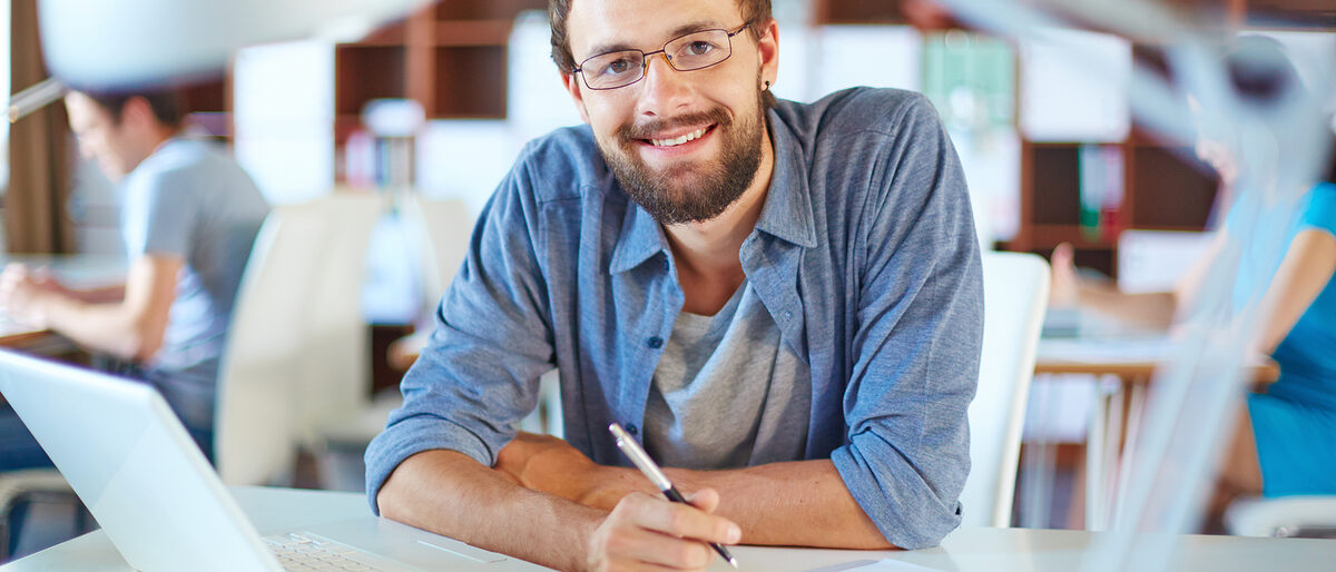 Büro, Mann, Arbeitsplatz, Arbeiten, junger Mann, Laptop, Statistik, Schreibtisch, Stift, erfolgreich, Lächeln, freundlich, kompetent, people, person, businesspeople, lifestyle, male, man, businessman, woman, female, business, contemporary, corporate, work, executive, job, employment, busy, career, young, adult, foreground, background, workplace, document, handsome, confident, successful, Caucasian, positive, casual, laptop, occupation, data, information, planning, expertise, bearded, eyeglasses, sitting, pc, looking, happy, smiling, profession, professional, pen, toothy, smiley, attractive, masculine