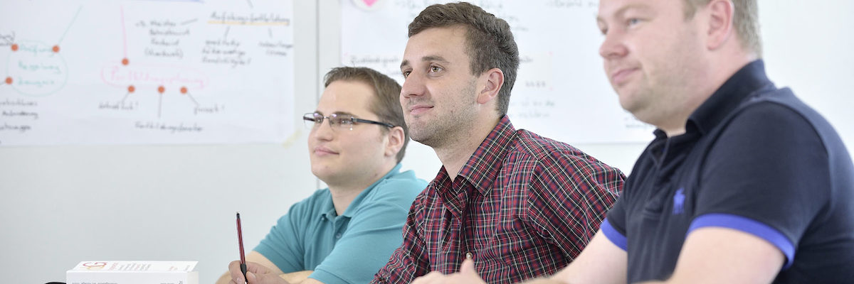 Meisterausbildung, Blick in die Klasse, drei junge Meisterschüler, Unterricht, Ordner, Gesetzestexte auf dem Tisch, Meistertitel 15579 argum