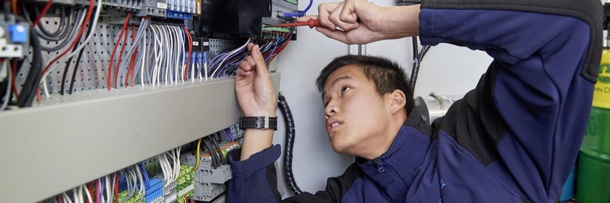 Giese Energie und Regeltechnik in Puchheim bei München. Schlagwort(e): Mann, blau, Schraubenzieher, Kabel, Elektronik, Arbeit, Soziales, Ausbildung