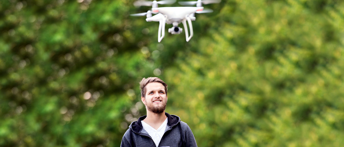 Young hipster man with remote control and flying drone with camera. Green sunny nature. Young hipster man with remote control and flying drone with camera. Green sunny nature. Schlagwort(e): drone, quadrocopter, white, isometric, camera, aircraft, air, technology, fly, vehicle, aviation, 3d, digital, modern, future, flight, control, wireless, aerial, propeller, spy, action, flying, motion, helicopter, quadcopter, professional, man, equipment, remote, hipster, beard, mustache, remote control, tablet, device, gadget, nature, green, sunny, sunlight, tree, forest, summer, sweatshirt, landing gear, filming, take photo, take picture, drone, quadrocopter, white, isometric, camera, aircraft, air, technology, fly, vehicle, aviation, 3d, digital, modern, future, flight, control, wireless, aerial, propeller, spy, action, flying, motion, helicopter, quadcopter, professional, man, equipment, remote, hipster, beard, mustache, remote control, tablet, device, gadget, nature, green, sunny, sunlight, tree, forest, summer, sweatshirt, landing gear, filming, take photo, take picture