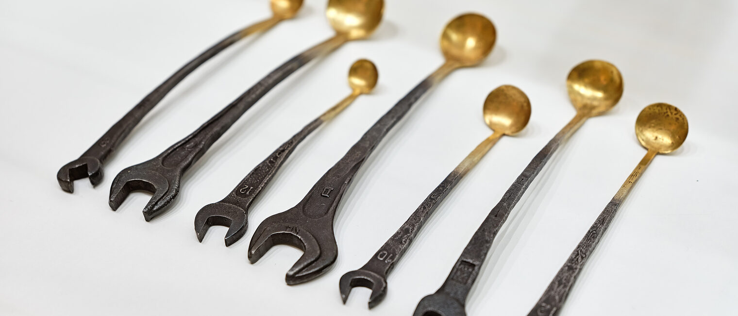 Schraubenschlüssel-Löffel Besteck, das halb Schraubenschlüssel, halb Löffel darstellt. Das Werkzeug wird zum Kunstobjekt. Kunsthandwerk - Werkzeug