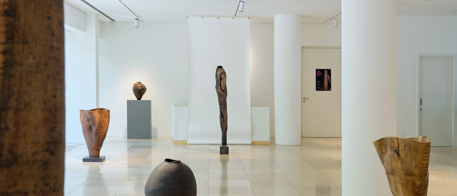 Sechs Holzskulpturen vom Kunsthandwerker Ernst Gamperl verteilen sich über den Säulenraum der lichtdurchfluteten Galerie Handwerk