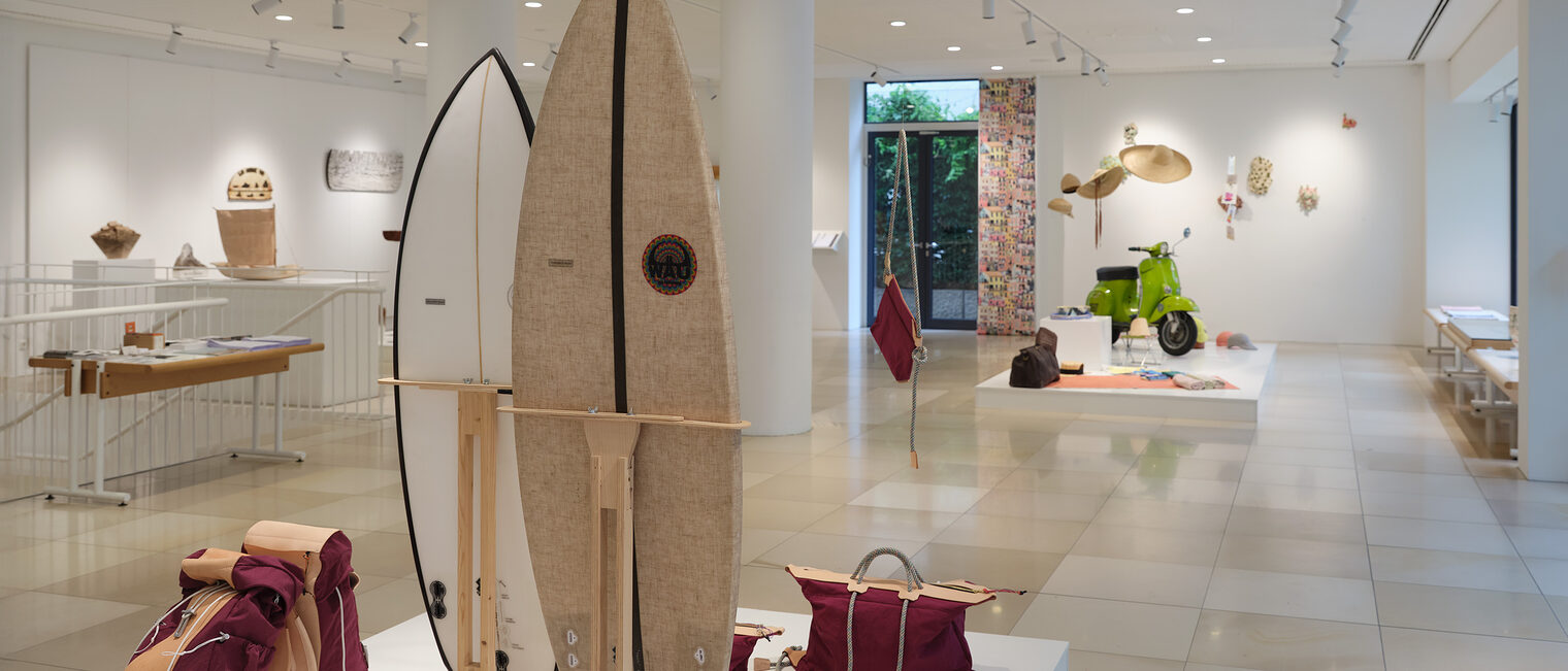 Impressionen aus der Ausstellung Woanders ist es auch schön mit Surfbrettern, nostalgischen Reisetaschen, Sonnenhüten etc.