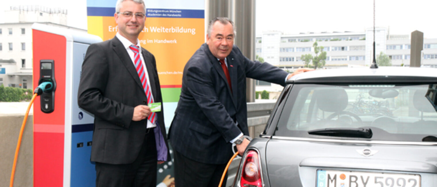 Handwerkskammerpräsident Heinrich Traublinger, MdL a. D.(rechts) und Dr. Wilfried Ruß von den Stadtwerken München nahmen die Stromtankstelle beim Bildungszentrum München der Handwerkskammer in Betrieb.