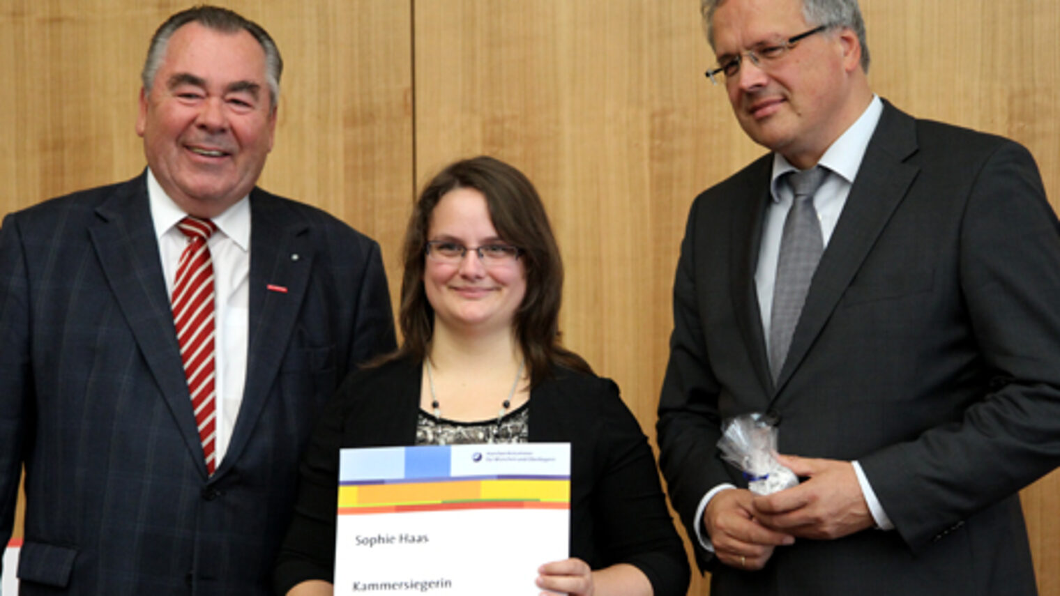 Kammerpräsident Heinrich Traublinger, MdL a. D. (links) und Regierungspräsident Christoph Hillenbrand (rechts) gratulierten Bürokauffrau Sophie Haas zum Kammersieg. Sie wurde in der Handwerkskammer für München und Oberbayern ausgebildet.